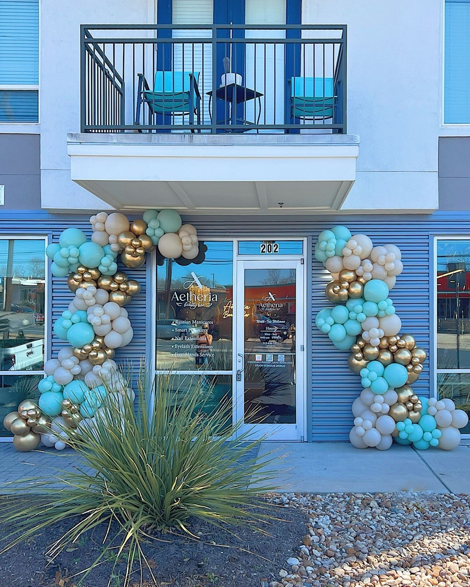 Balloon arch in front of a party backdrop